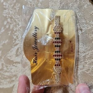 Hair clip with colors red and green and white jems.